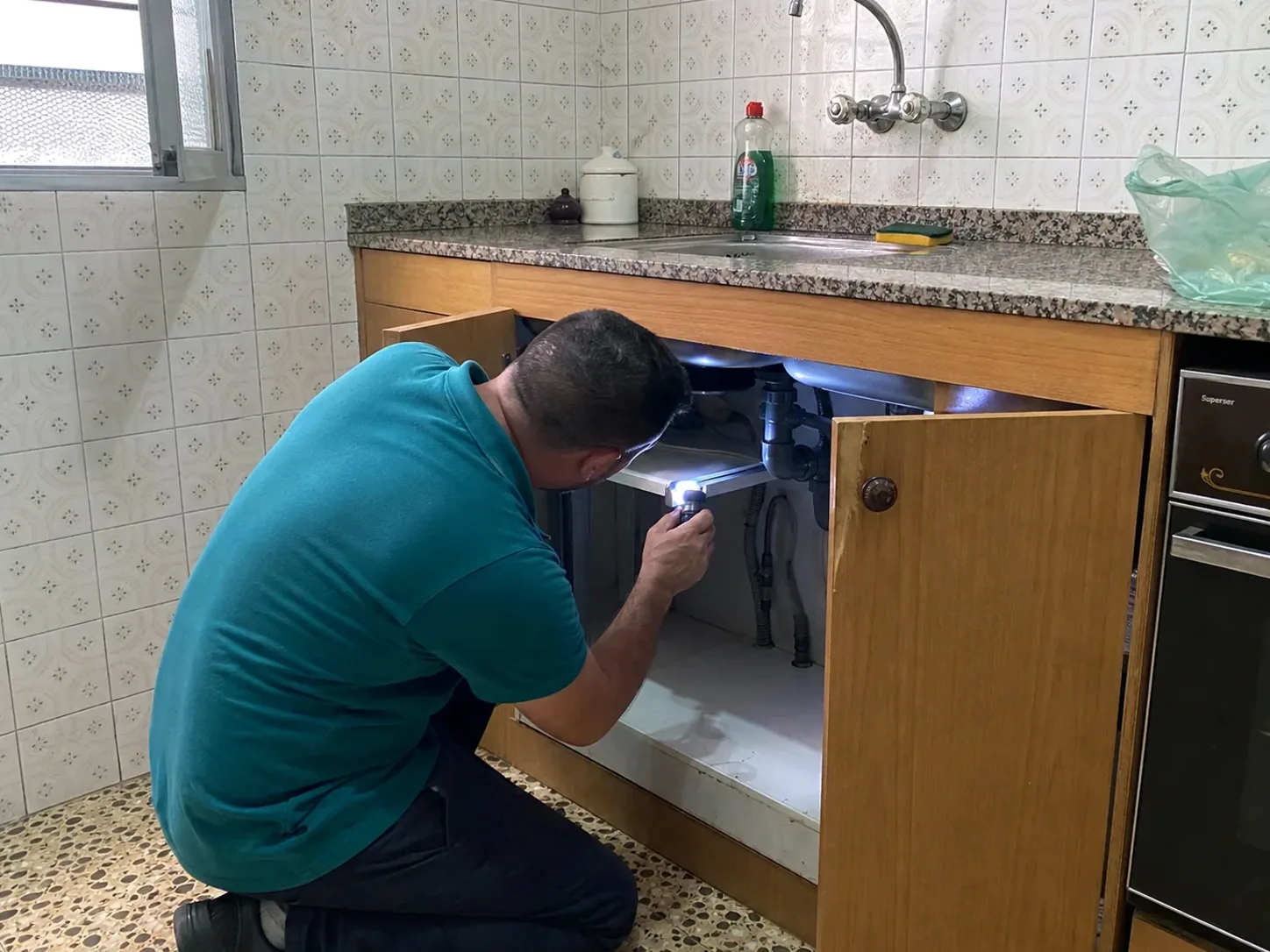 Técnico de LlinarsPlagas inspeccionando una cocina con linterna